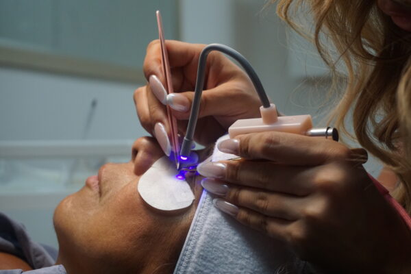Lynk-Gel Method. Handhled, touch sensor device. Lash extensions applied with LED curable glue.